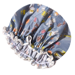 Detail of blue waterproof shower cap with cartoon rabbit pattern and elastic hem