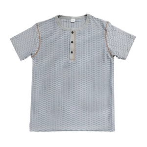 Détail du tissu gaufré et du col Henley avec coutures contrastées sur le t-shirt bleu gris