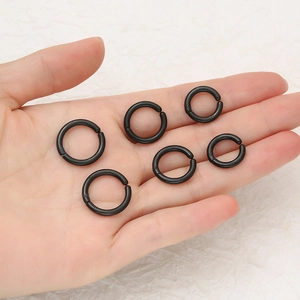 Lot de six boucles d'oreilles clips noires en acier inoxydable style hip-hop sur main