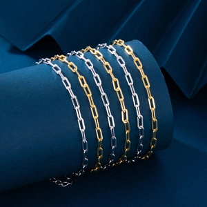 Close-up of gold and silver paperclip chain links wrapped on a blue cylinder