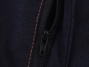 Detail of dark blue knit fabric featuring black zipper closure and orange contrast stitching