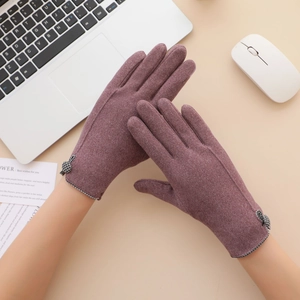 Detail of warm winter gloves with elegant bow accent and touchscreen fabric texture
