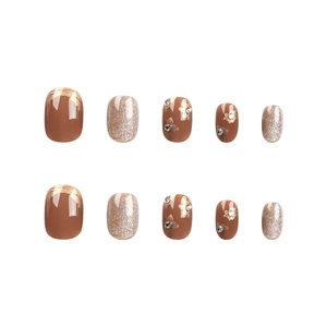 Short round press-on nails in caramel and silver with floral art and rhinestones