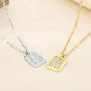 Detailed macro view of gold and silver rectangular heart necklaces with sparkling rhinestones