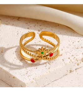 Detailed view of vintage gold ring with red and green enamel on white stone base
