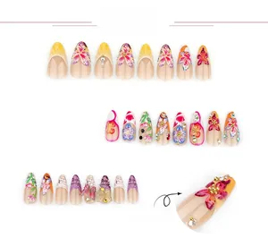 Vue détaillée de faux ongles 3D avec motifs floraux, papillons et strass brillants