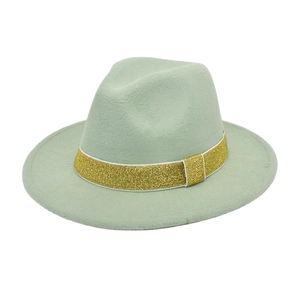 Close-up of light green wool fedora hat with elegant gold glitter ribbon decoration
