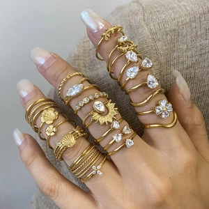 Detailed view of layered gold-tone titanium rings with zircons on a hand