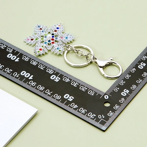 Sparkling snowflake keychain with colorful rhinestones and white pearl on silver metal
