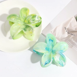 Detailed macro view of floral hair claws featuring marble texture in gradient tones