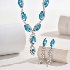 Macro shot of blue marquise crystal jewelry set with sparkling tassels on stone decor