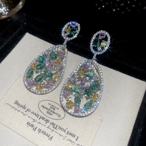 Macro shot of luxury colorful oval zircon teardrop earrings on velvet jewelry box