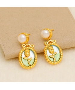Detailed close-up of French vintage tulip pearl earrings with gold rose relief work