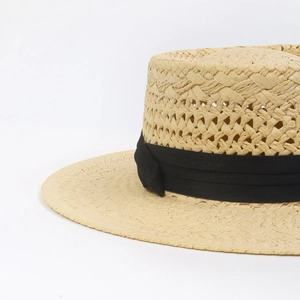 Close-up of handwoven straw hat showing fine texture and black decorative ribbon