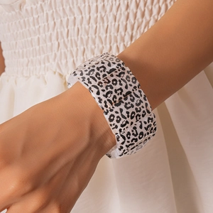 Close-up of a wide leopard print acrylic bracelet on wrist with textured resin details