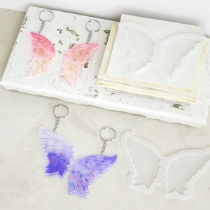 Macro detail of butterfly wing silicone mold with resin keychain and glitter accents