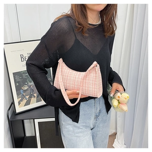 Sac bandoulière en tweed rose porté avec un top en tulle noir et un jean décontracté