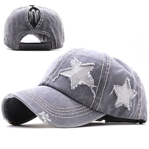 Dettaglio del cappello a coda di cavallo in denim lavato con toppa a stella ed effetto consumato