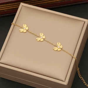 Golden butterfly necklace with pink marquise crystals on a beige jewelry gift box