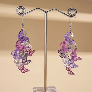 Detail view of hollow butterfly tassel earrings with purple and pink gradient metal finish
