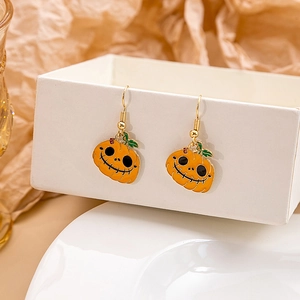 Detalle de pendientes de calabaza naranja con ganchos dorados para fiesta Halloween