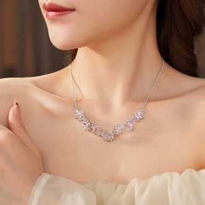 Detail of silver necklace with pink gemstone flowers and diamonds on model