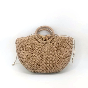 Detail der halbmondförmigen Strohhandtasche mit runden Griffen und Kordelzug-Innenfutter