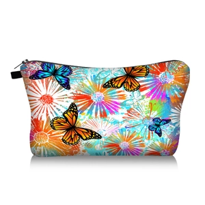 Detail of vibrant butterfly and daisy floral print on a travel cosmetic storage pouch