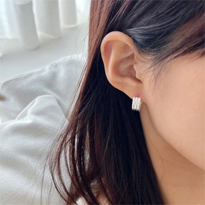 Close-up of minimalist silver layered ear cuff with sleek vertical ridge textures