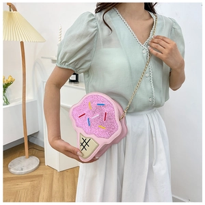 Model wearing a pink ice cream shaped crossbody bag with glitter finish and gold chain