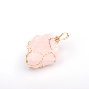 Detail of handmade gold wire-wrapped rose quartz crystal pendant on white background