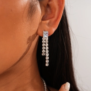 Close-up of elegant silver geometric rectangle earrings with long dangling zircon tassels