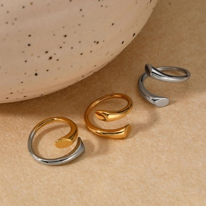Minimalist stainless steel spiral open rings in gold and silver finish on ceramic decor