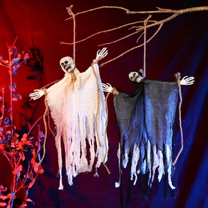 Close-up of hanging Halloween ghosts with skull heads in black and white tattered gauze