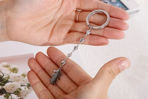 Detailed view of silver stainless steel heart chain keychain with female silhouette charm
