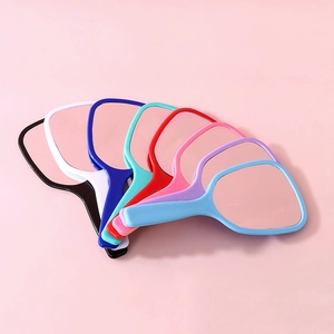Eight colorful handheld makeup mirrors fan out on a soft pink background for daily use