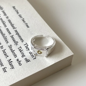 Macro shot of silver textured ring with champagne gemstone on an open book