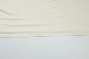 Detailed view of the even stitching and smooth knit fabric texture on the cream off-shoulder set