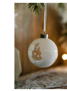 Close-up of 8cm glass Christmas ball with golden snowman pattern and snow filling