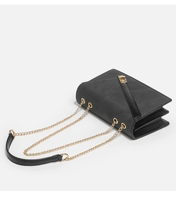 Detail of black crossbody bag with gold chain strap and high-quality leather texture