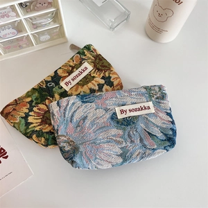 Detail of vintage embossed floral toiletry bags with rich jacquard fabric and metal zipper