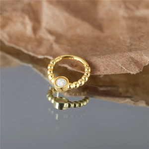Detail of gold-plated silver hoop with white opal stone and beaded edge texture