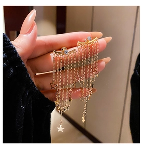 Detailed view of gold tassel star earrings featuring sparkling rhinestones and chains