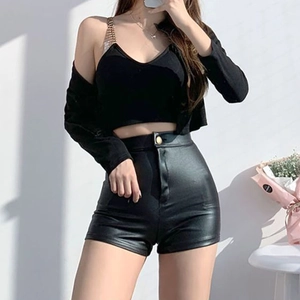 Detail der schwarzen High-Waist-PU-Ledershorts mit einem Camisole-Top mit Metallkette