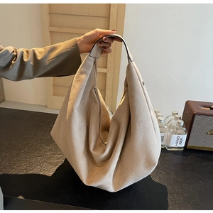 Detail of khaki suede tote bag with minimalist crescent design and soft matte texture