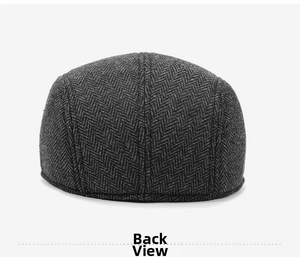 Detail view of the back stitching and grey herringbone wool texture of a men's flat cap