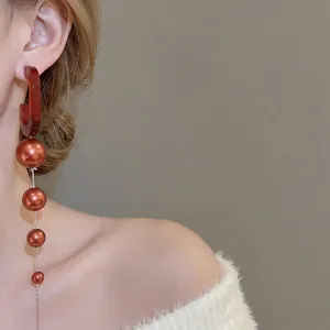 Elegant retro oval pearl tassel earrings with deep red C-shape design and orange beads