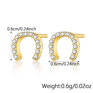 Macro view of gold horseshoe stud earrings with pavé set white zircon and size details