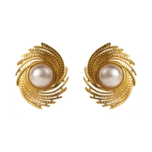 Détail de boucles d'oreilles tourbillons dorées avec perles blanches centrales
