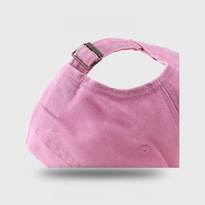 Close-up of pink denim baseball cap with adjustable bronze metal buckle and twill fabric
